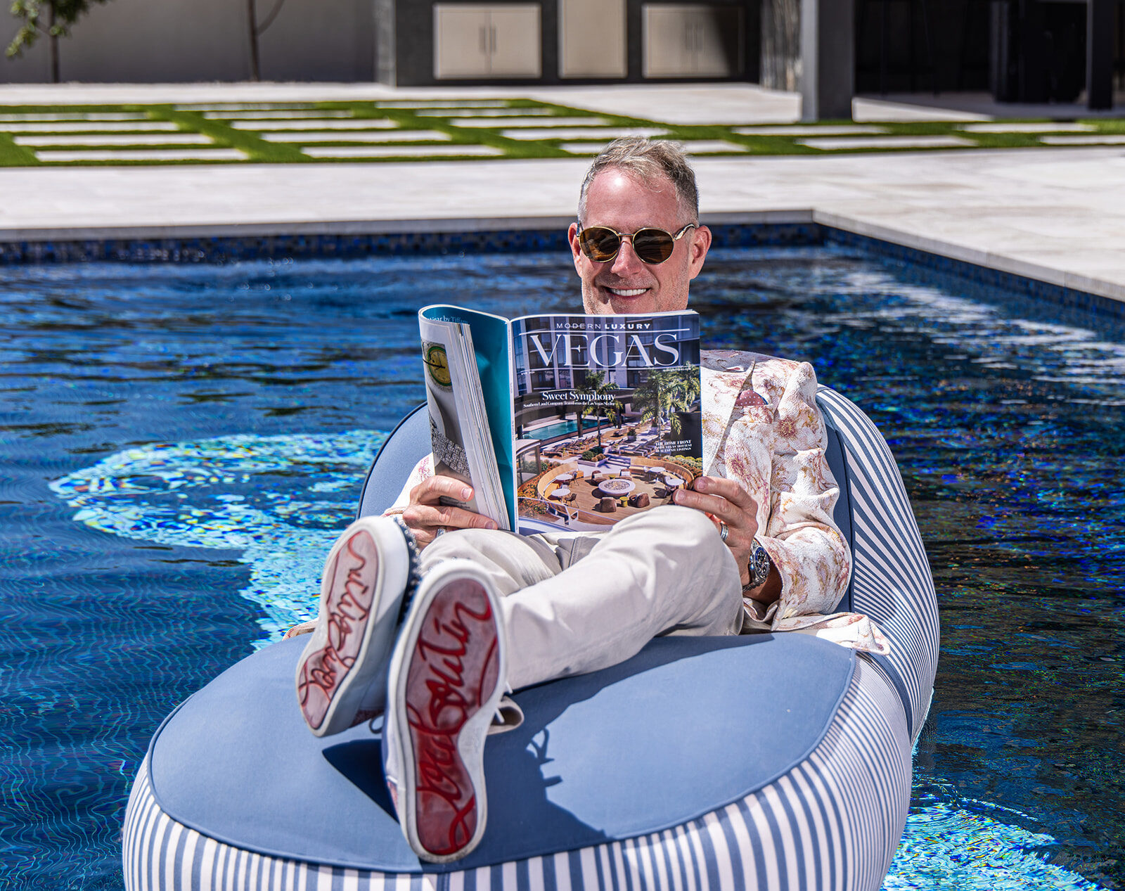 Jonny Moore reading the Modern Luxury Vegas feature while floating in his own pool